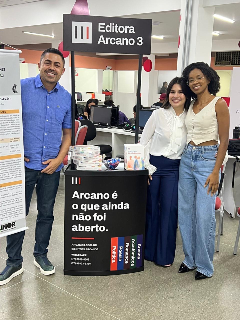 Três pessoas junto ao estande da Editora Arcano 3